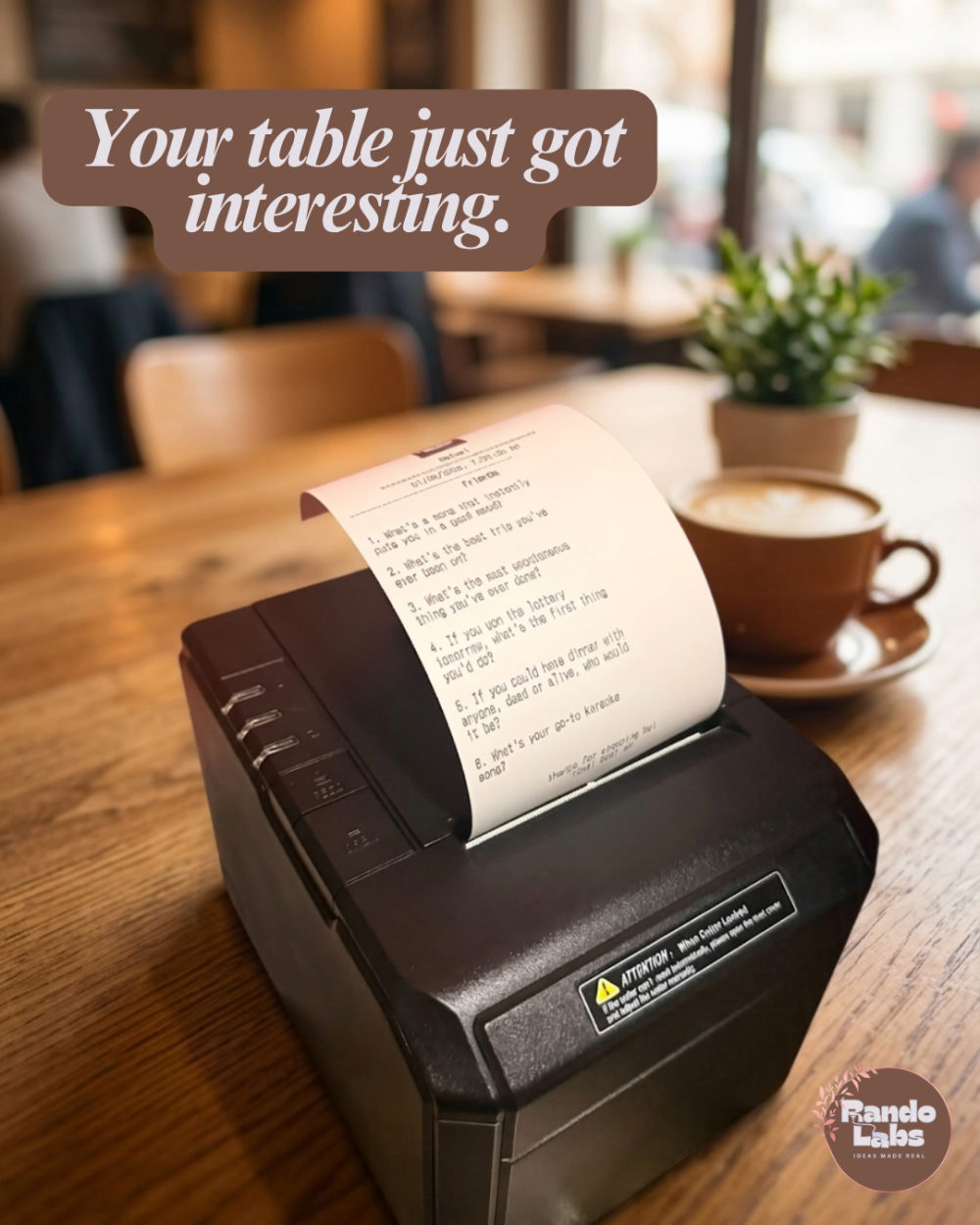 TableCade printer on a real cafe table, printing an icebreaker receipt next to a coffee